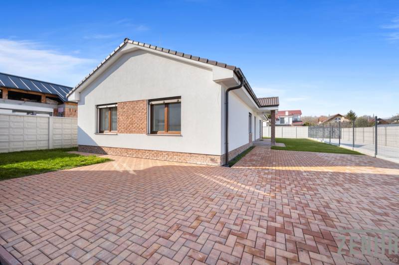 A family house in Vojka nad Dunajom with a brick facade and a paved courtyard.