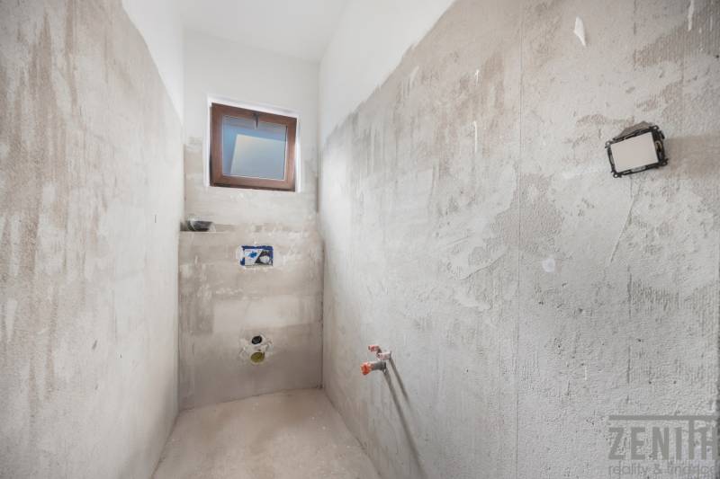 Building a bathroom in a family house with a window and concrete walls.