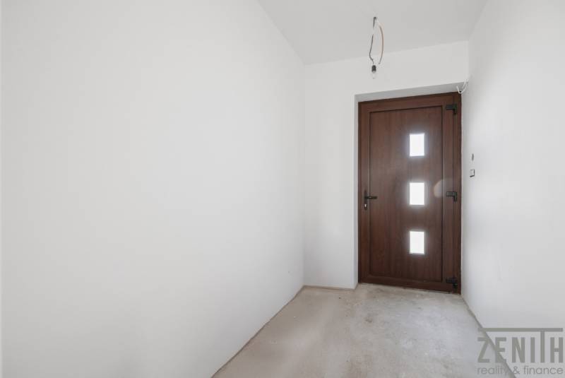 Entrance hall in a family house with white walls and wooden doors.