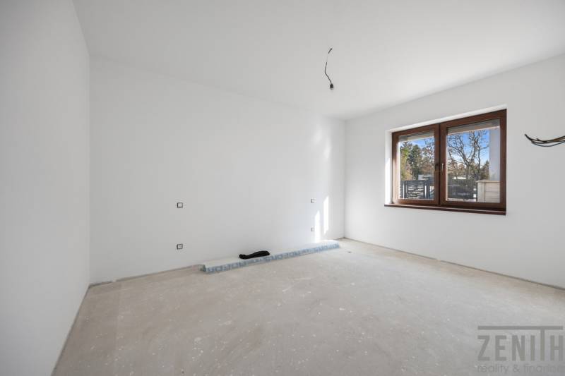 Empty room with white walls and a large window in a family house.