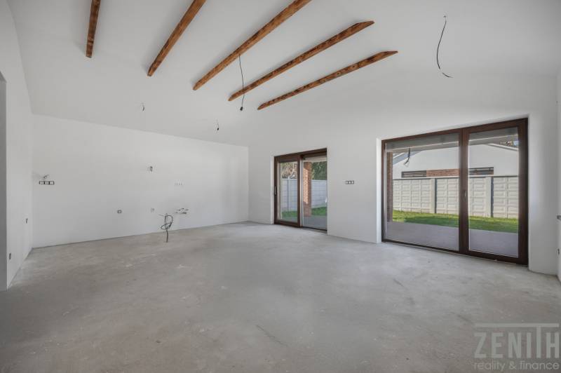 A spacious room with beams and windows to the terrace in a family house.