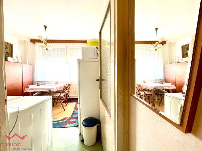 A dining room with wooden decor, a kitchen table, and a mirror in a studio apartment.