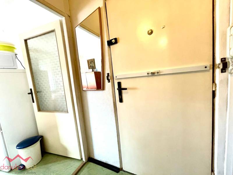 Entrance door in a one-room apartment with a wall mirror and a built-in cabinet intercom.