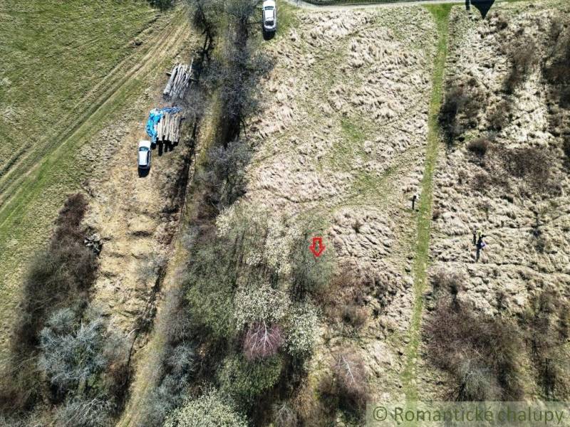 Plots - living in Vydrná with nature and cars parked on grassy terrain.