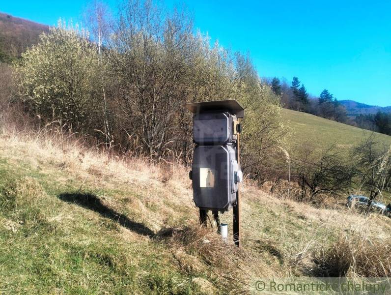 Plots - housing in Vydrná: Electrical switchboard on a meadow with a forest background.
