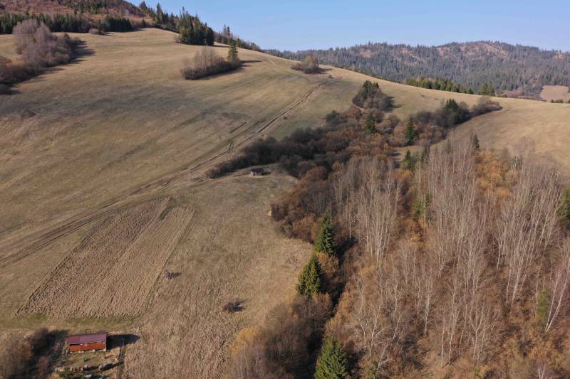 A hilly landscape of agricultural and forest land near Námestovo with a wooden structure.
