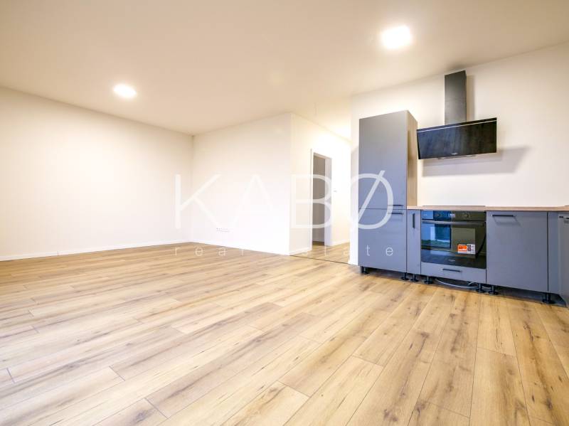 A kitchen in a family house with a kitchen unit and a floor with a wooden decor.