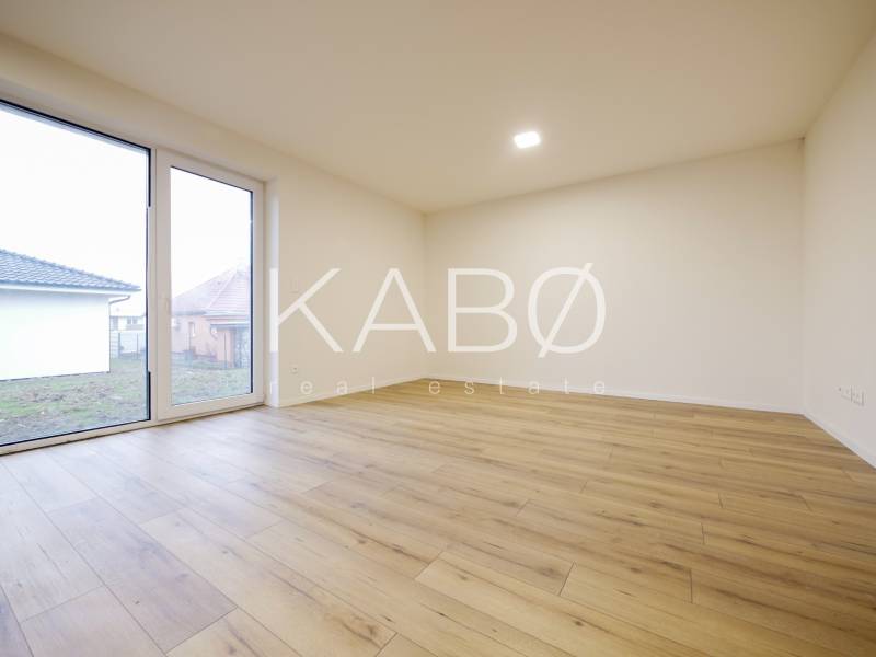 A room in a family house with a wooden decor floor and large windows.