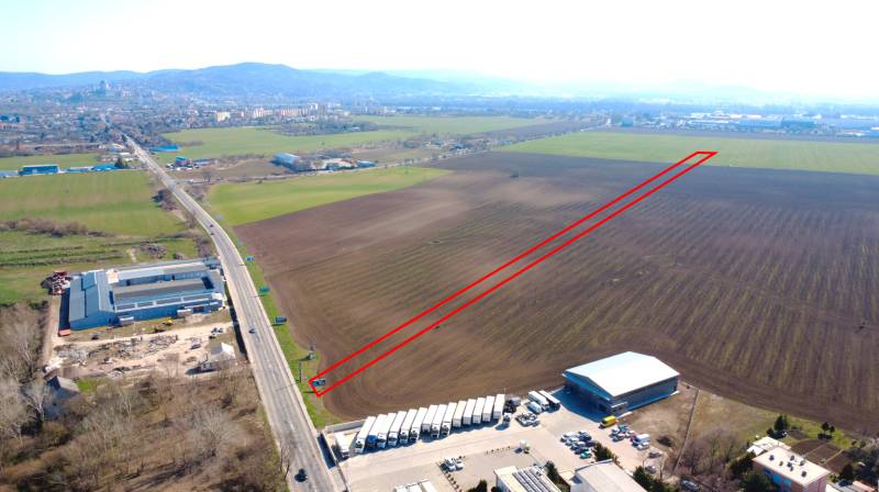 Agricultural and forest lands in Štúrovo with extensive flat areas and an adjacent road.