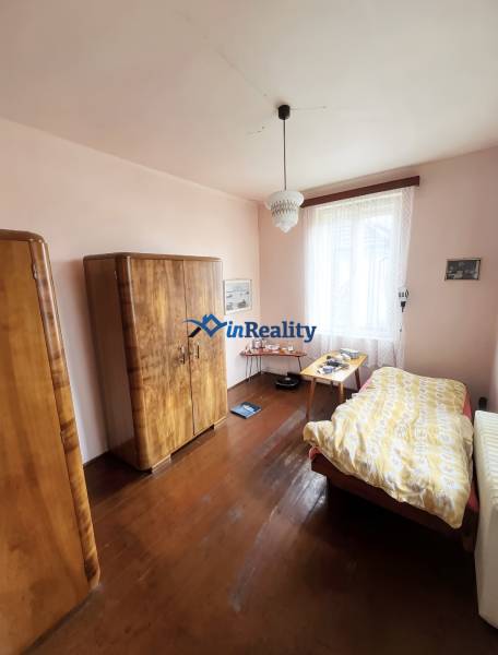 A room in a family house with a wooden decor floor, furniture, and a chandelier.
