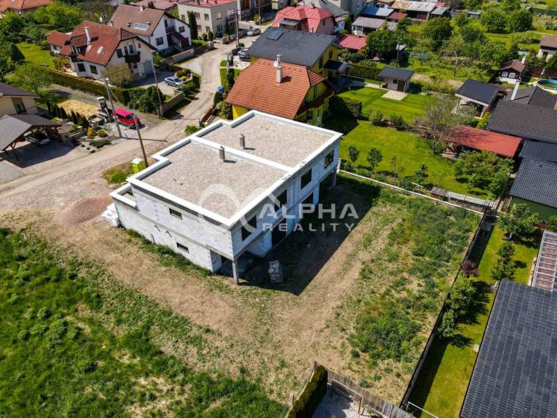Aerial view of an unfinished family house in Harichovce with a spacious plot of land surrounding it.