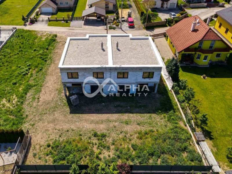 A family house in Harichovce in the exterior, surrounded by greenery and neighboring houses.