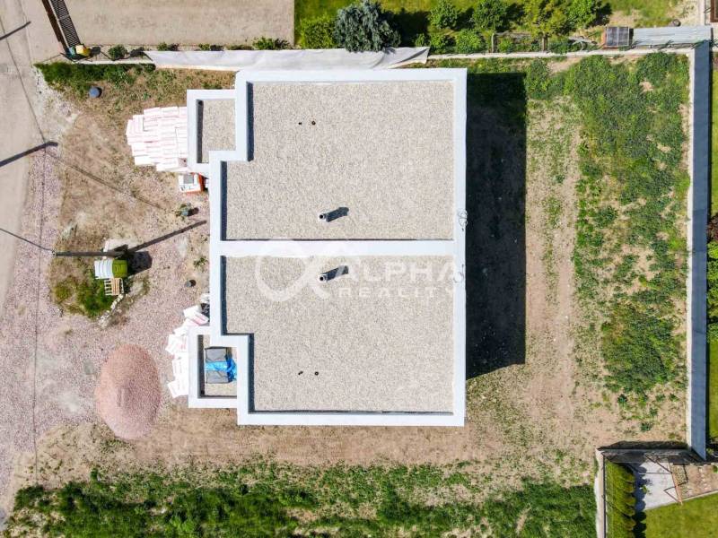 Construction of a family house in Harichovce, aerial view, with vacant plots around the construction site.