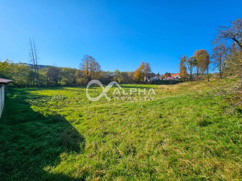 A residential plot in Spišské Podhradie with a view of greenery and nearby houses.