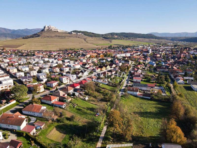 Aerial view of residential land in Spišské Podhradie with the castle in the background.