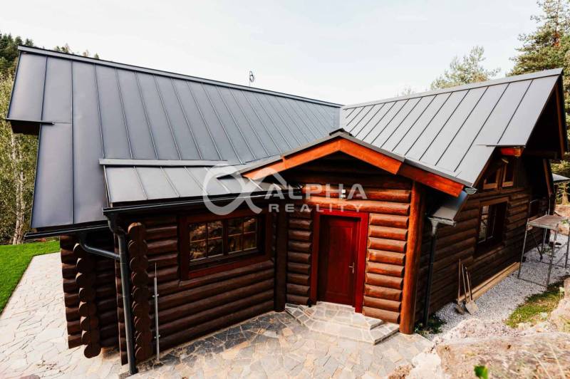 A family house in Hnilčík with a sheet metal roof and wooden wall cladding.
