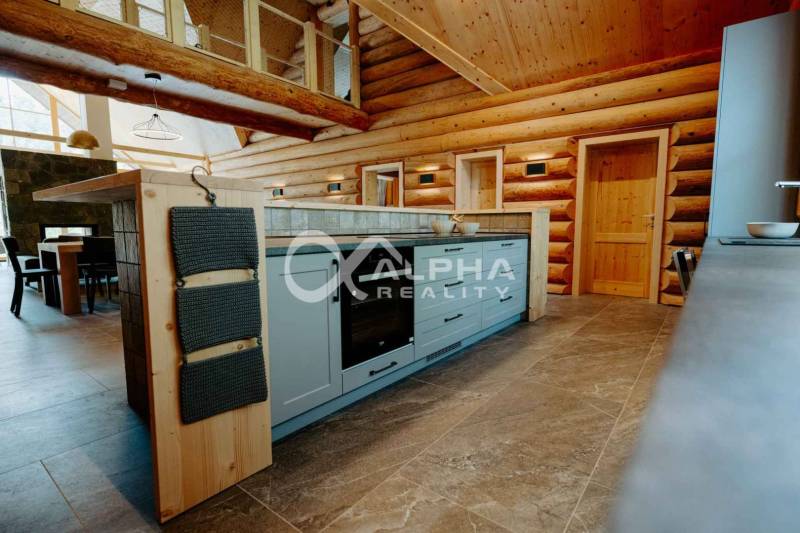 A kitchen in a family house with a wooden decor floor and wooden walls.