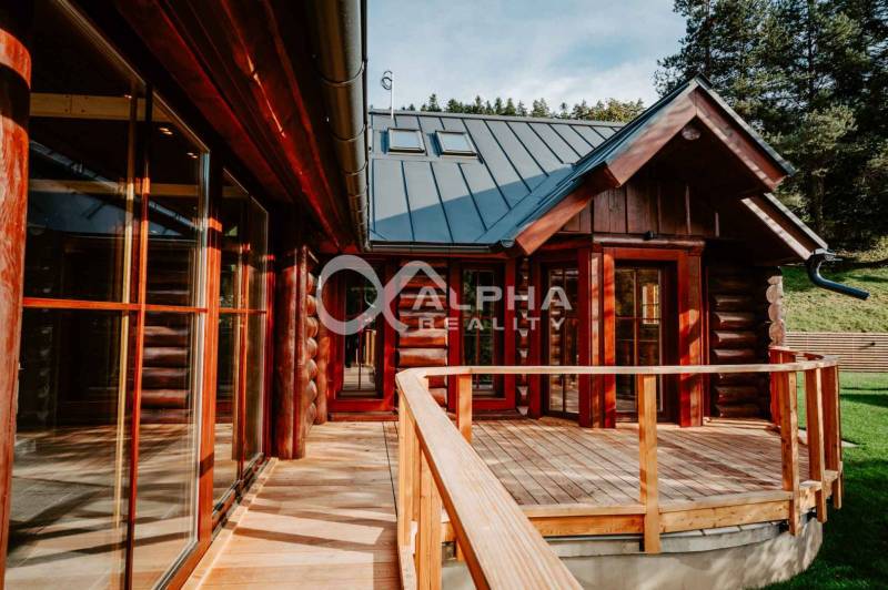 A family house in Hnilčík with a wooden terrace surrounded by nature and forest.