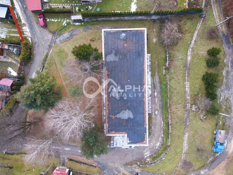 An aerial view of a building in Helcmanovce surrounded by trees and driveways.