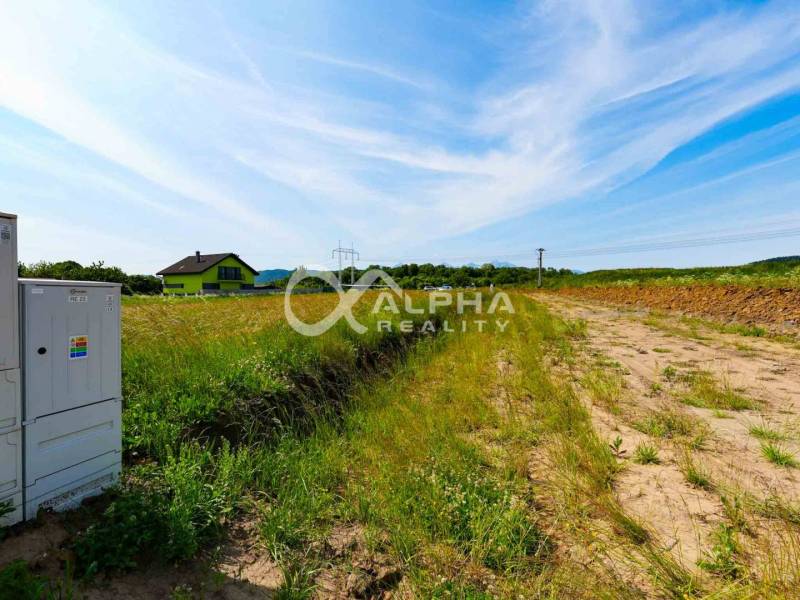 Plots - housing in Betlanovce, grass, field, electrical cabinets, house and blue sky.
