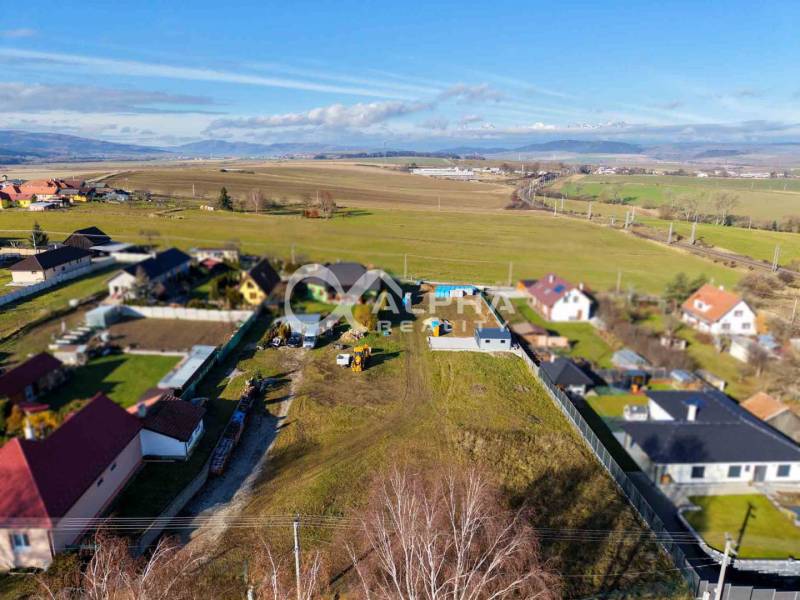 Exterior in Spišské Tomášovce, plots - residential, with a view of the surrounding fields and houses.