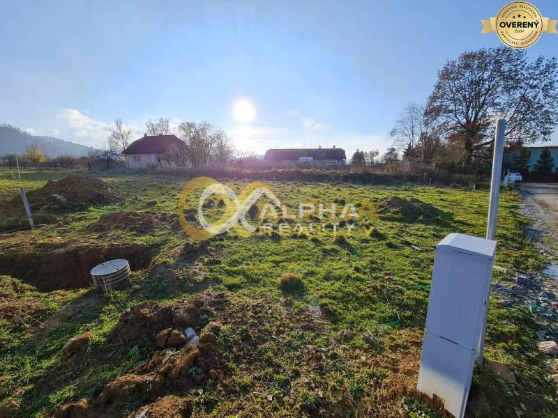 Plots - residential in Markušovce, grassy area with a view of the surrounding houses and trees.