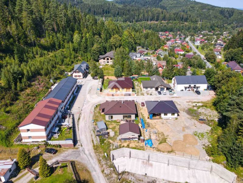 An aerial view of a village surrounded by forests and houses near Spišská Nová Ves.