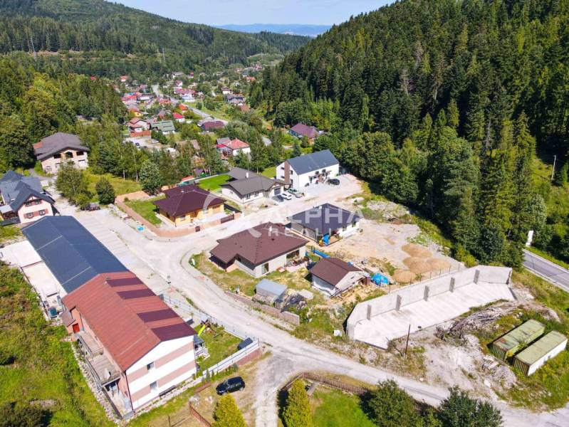 An aerial view of a small village surrounded by forests near Spišská Nová Ves.