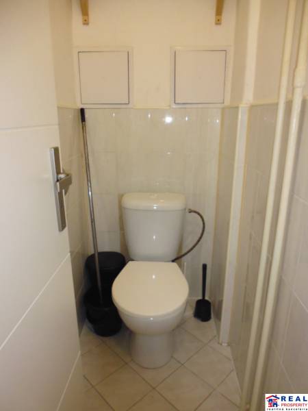 Small bathroom with toilet and tiles in a studio apartment.
