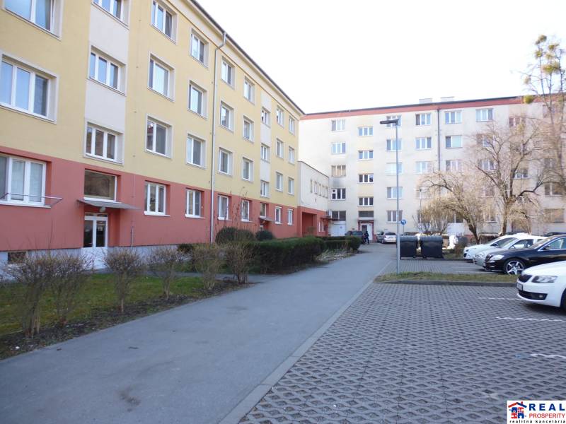 Apartment building on 17. novembra Street in Prešov with a parking lot in the foreground.