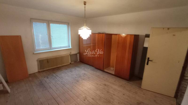 A room with wooden decor, a wardrobe, and a window in a family house.