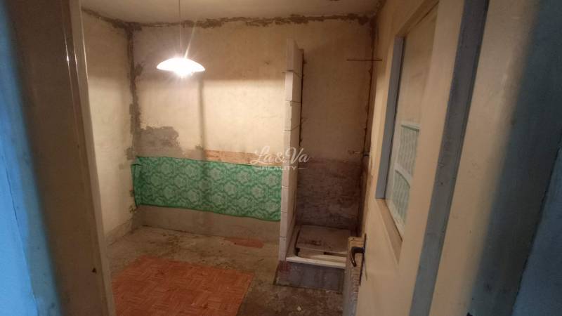Unsuitable bathroom in a family house with exposed pipes and an older shower enclosure.