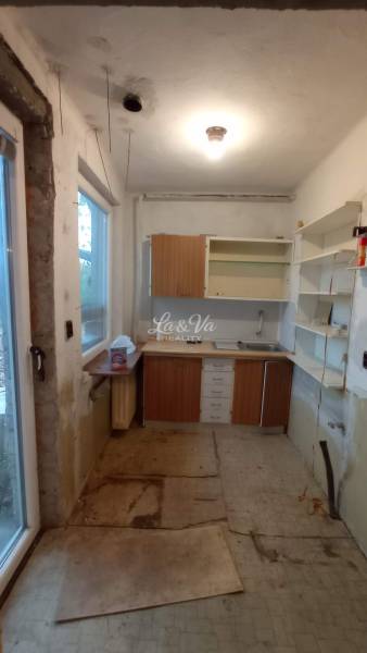 A kitchen in a family house with incomplete renovation and storage space.
