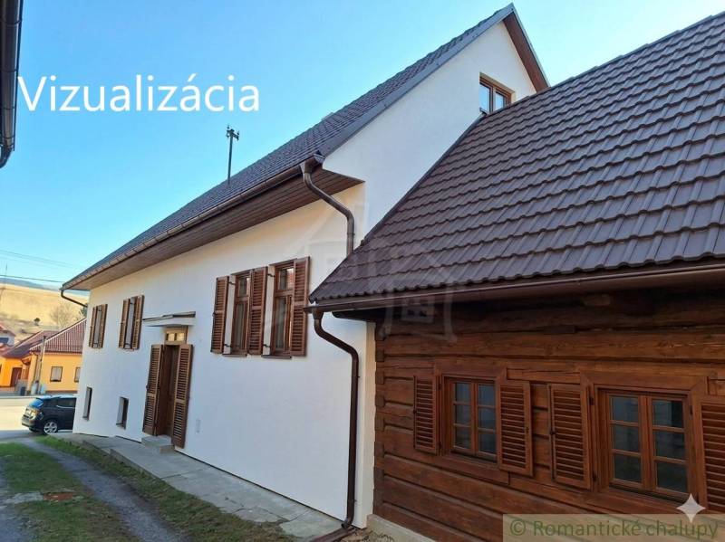 A family house in Východná with a white facade and brown shutters.