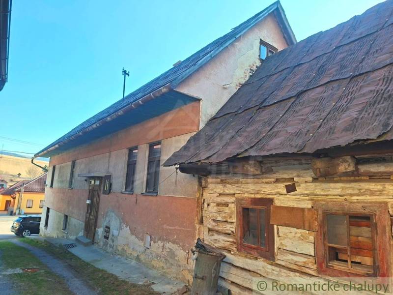 A family house in Východná with a wooden facade and a yard, under a blue sky.