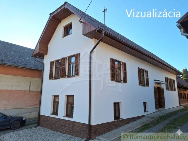 A family house in Východná with a white facade and wooden shutters.