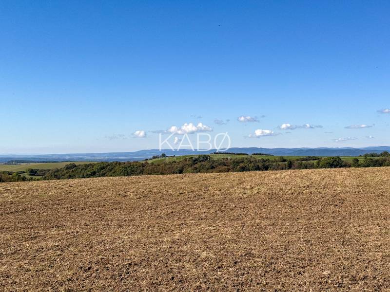 Extensive agricultural and forest lands near Lackov with a panoramic view of the hills.