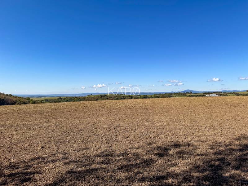 Agricultural and forest land in Lackov with views of the hills and blue sky.
