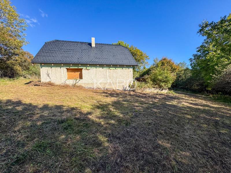 A stone structure surrounded by vegetation on agricultural and forest land in Lackov.