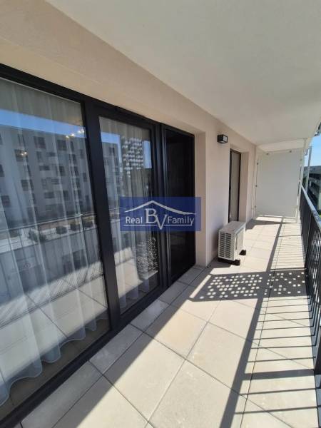 The balcony of a 2-room apartment on Eduarda Wenzla Street in Bratislava - Rača with glass doors.