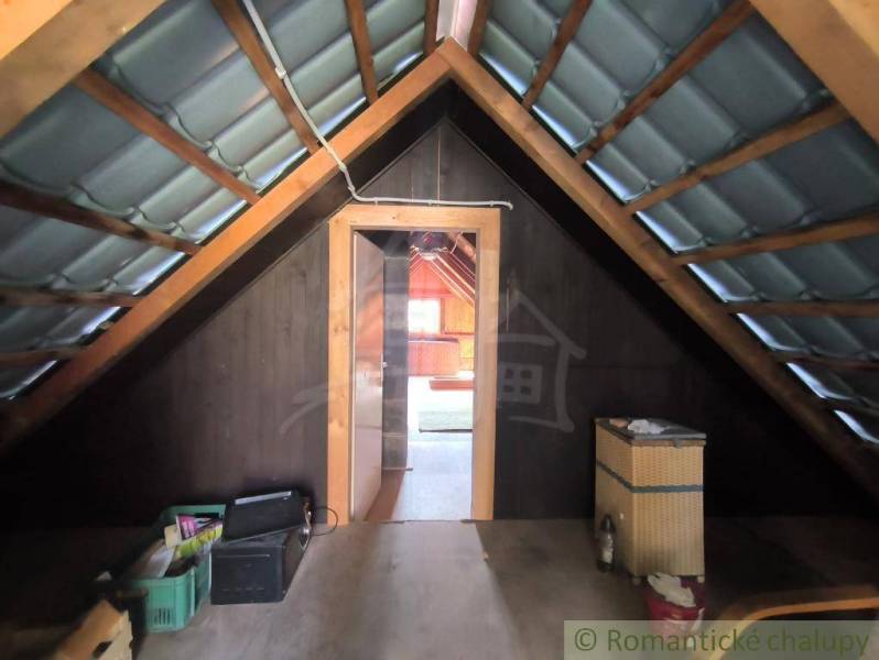 The attic of a cottage with wooden decor, view through the open entrance.