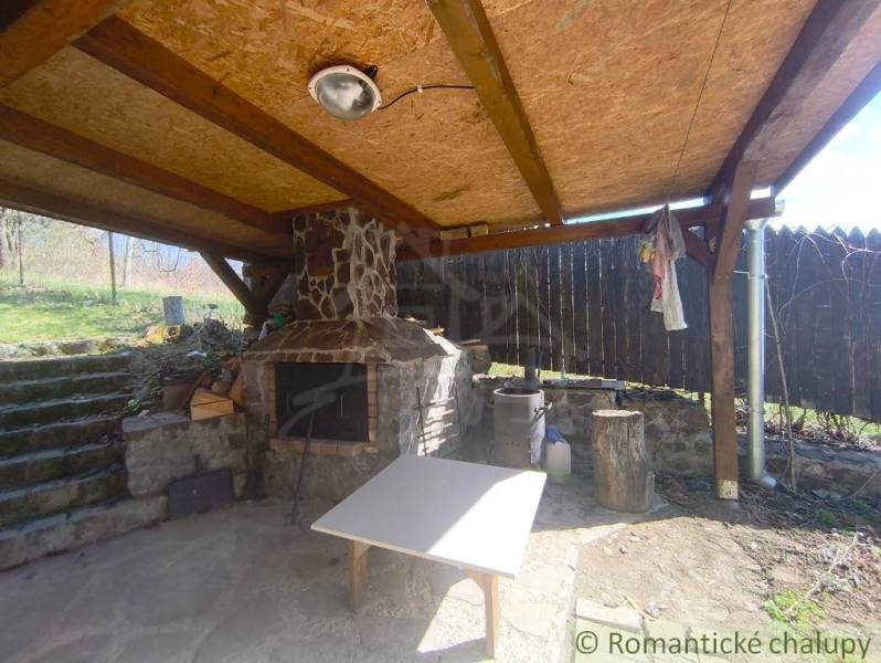 Covered gazebo with a stone grill in a cottage in Hronská Dúbrava.
