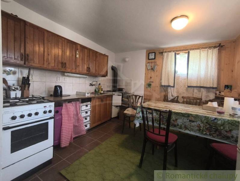 A cottage kitchen with wooden decor and simple furnishings.