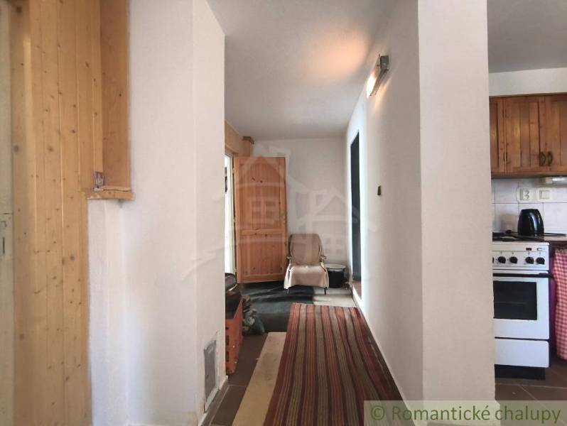 Interior of a cabin with wooden elements and a kitchenette.