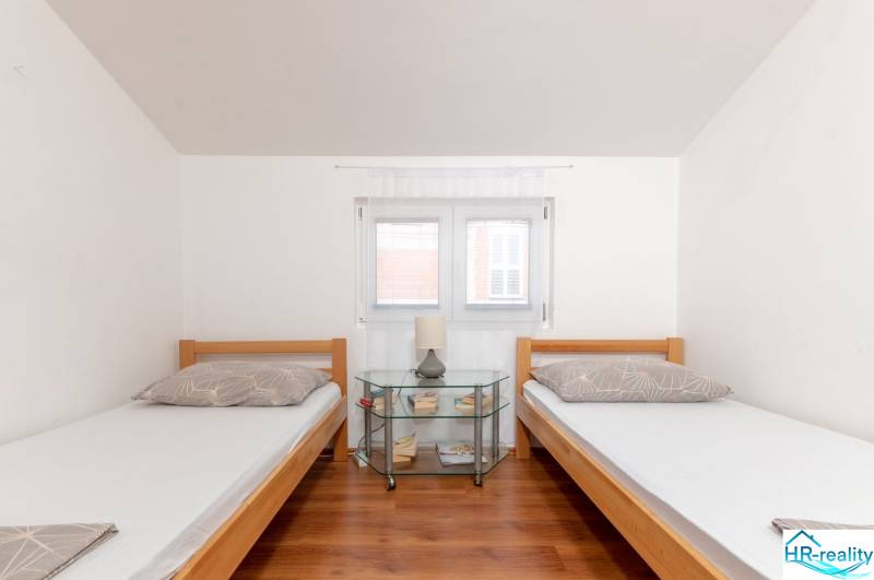 Recreational apartment: Two single beds with a nightstand and a wooden decor floor.