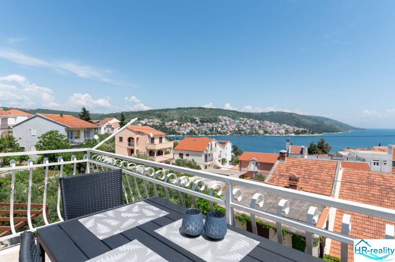 The view from the terrace of the holiday apartment in Ciovo of the sea and surrounding houses with red roofs.