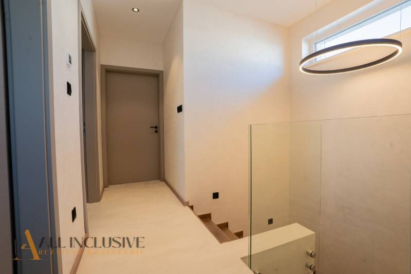 A hallway in a family house with a circular light fixture and wooden doors.