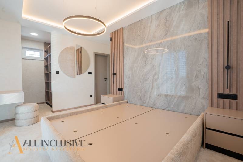 The interior of a family house with light walls, circular lighting, and built-in shelves.