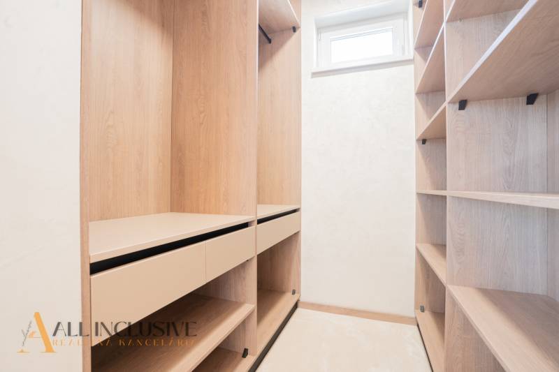 A wardrobe with a wooden decor and storage spaces in a family house.