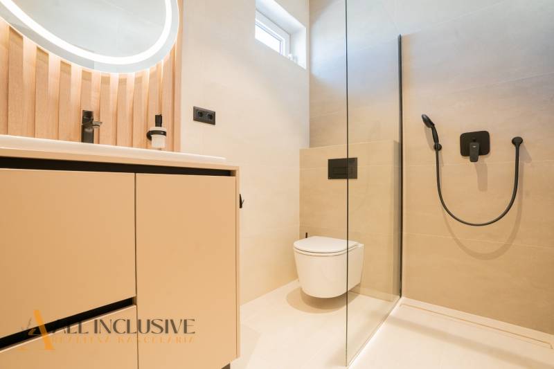 A bathroom in a family house with a shower and wooden decorative elements.